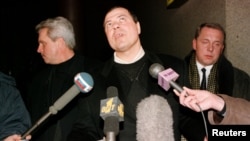 Sergei Mikhailov (center) speaks to the press at Moscow's Sheremetyevo airport on his return from Switzerland in December 1998. (file photo)