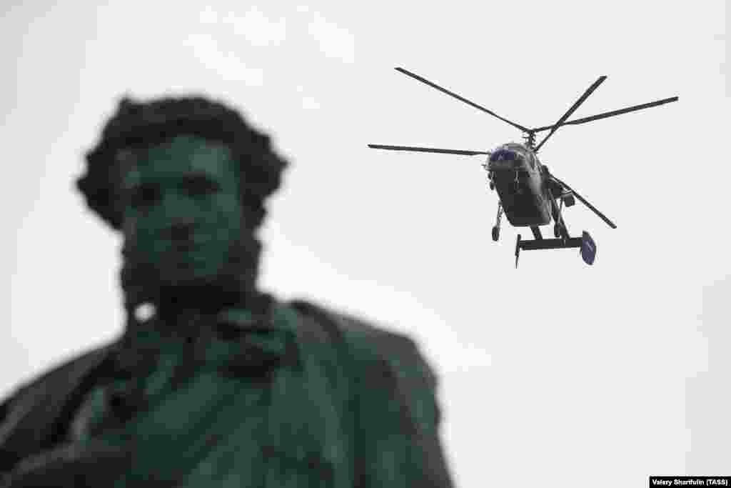 A helicopter flying over a statue of Russian poet Alexander Pushkin, in the square that bears his name.