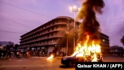 Smoke plumes from a police vehicle set on fire by supporters of Pakistan's blasphemy laws in the southern sea port city of Karachi in October 2024. (file photo)