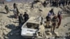 Taliban forces inspect a damaged car two days after air strikes by Pakistan in the Barmal district of eastern Afghanistan's Paktika Province on December 26.