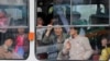 North Koreans look out of a tram as it passes by a department store in central Pyongyang. While some basic shopping is permitted, most North Koreans lived in poverty and rely on the state ration system for survival. 