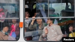 North Koreans look out of a tram as it passes by a department store in central Pyongyang. While some basic shopping is permitted, most North Koreans lived in poverty and rely on the state ration system for survival. 