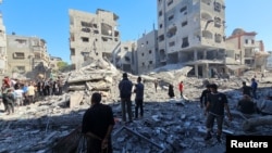 Palestinians gather at the site of Israeli air strikes on residential buildings in the Gaza Strip.
