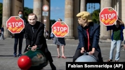 Two activists dressed up as U.S. President Trump and Russian President Putin ride two atomic bomb models during a protest in Berlin for a world without nuclear weapons. (file photo)