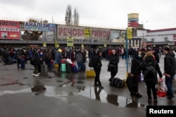 People gather at a bus station as they try to leave Kyiv on February 24.