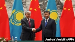 Chinese President Xi Jinping (right) shakes hands with Kazakh President Qasym-Zhomart Toqaev at the end of a signing ceremony at the Great Hall of the People in Beijing on September 11, 2019.