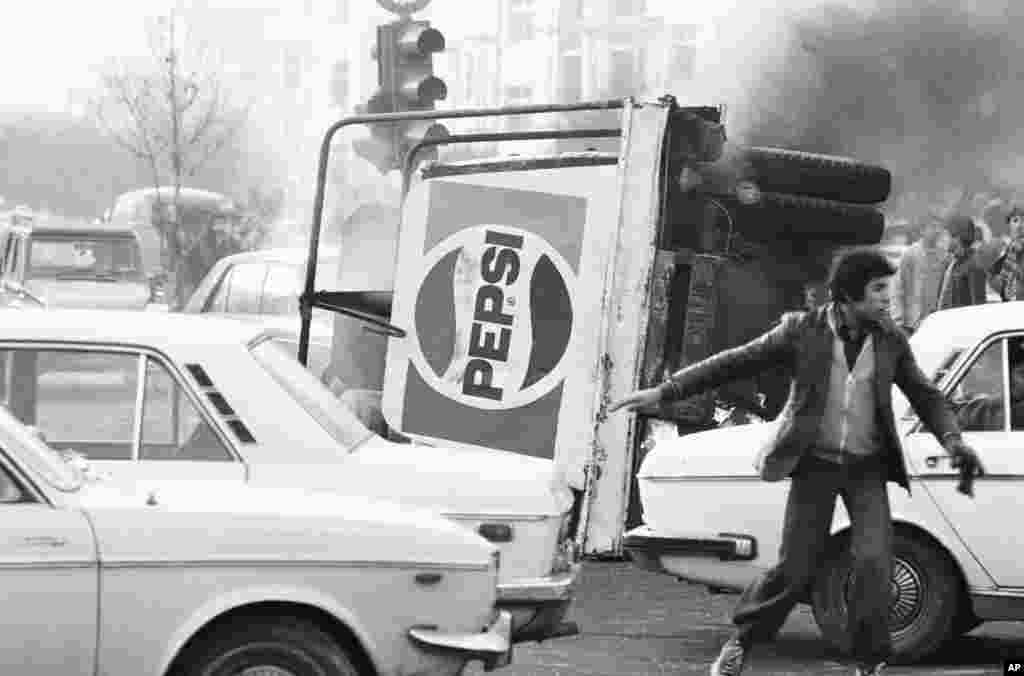 An overturned truck with a Pepsi logo burns in the center of Tehran during riots which paralyzed the city on December 27, 1978.