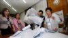 Azerbaijani election officials empty ballot boxes at a polling station in Baku on October 9.