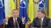 Ukrainian President Petro Poroshenko (right) listens to NATO General-Secretary Jens Stoltenberg in Kyiv in September 2015. The stripped-down July 13 meeting will be only the council's second since it resumed functioning in April after NATO suspended it in 2014 over Russia's occupation of Ukraine's Crimea region.