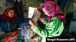 A woman casts a ballot at her home during early voting in Russia's parliamentary elections at a deer camp about 2,200 kilometers northeast of Moscow in the Tyumen region on September 9.