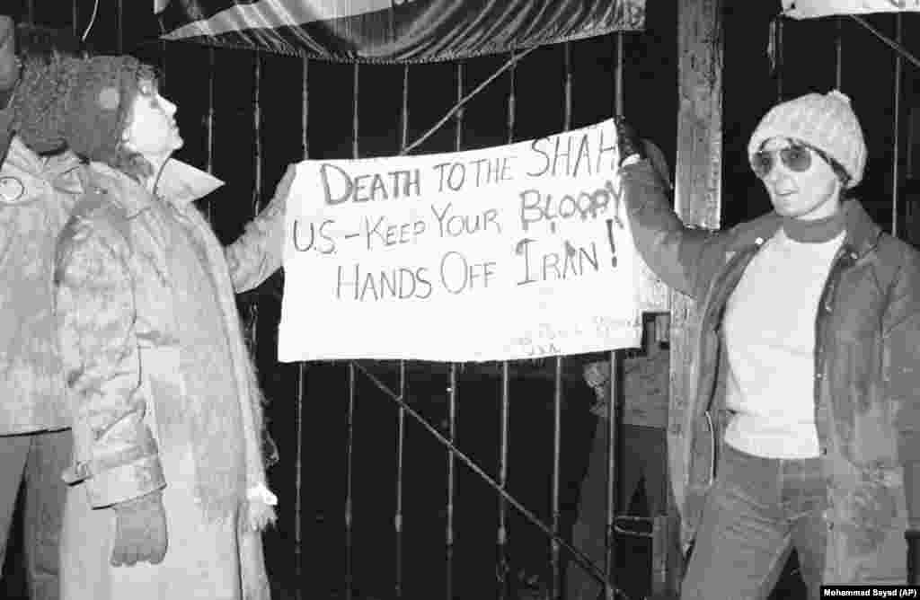 Some U.S. citizens were sympathetic to the Iranian students&rsquo; demands: Two Americans, Carol Downer (left) of Los Angeles and Rebecca Chalker (right) of Tallahassee, Florida, hold up a sign in front of the U.S. Embassy calling for the death of the shah on December 15, 1979. The sign was attributed to Chicago postal workers.