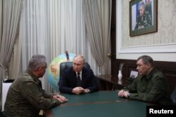 Putin meets with Defense Minister Sergei Shoigu (left) and Chief of the General Staff Valery Gerasimov to discuss the war against Ukraine during a visit to the Southern Military District headquarters in Rostov-on-Don in November 2023.