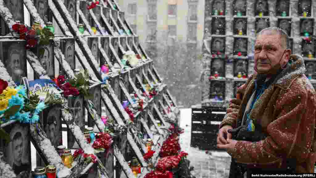 A man lights a candle at the memorial.