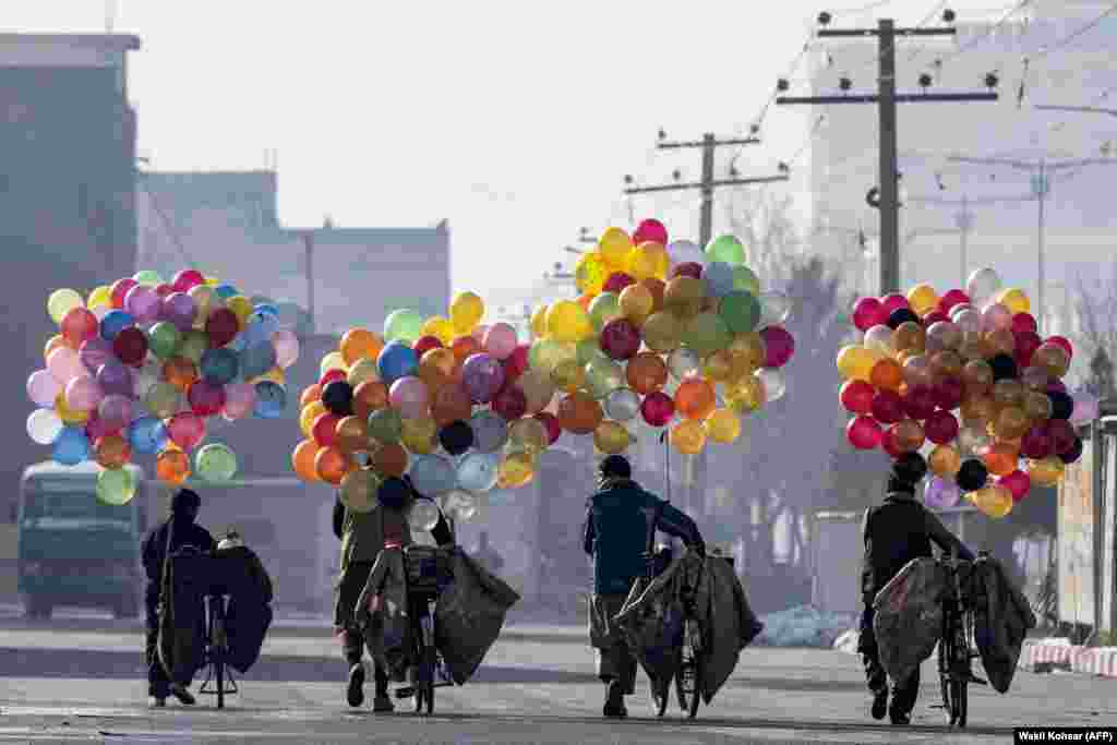 Afghan balloon vendors walk with their bicycles to look for customers near a market in Kabul.&nbsp;