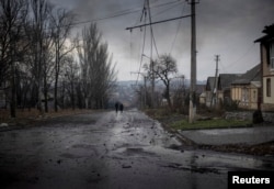 Local residents who have chosen to stay behind -- at least for now -- walk down a deserted street in Bakhmut on December 9.