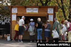 People receive free food at an outdoor "soup kitchen."