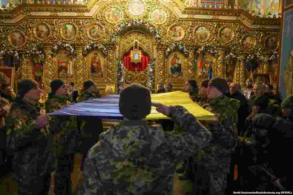 Ukrainian soldiers pay their respects to a fallen comrade at his funeral in Kyiv.