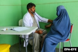 A health worker checks an internally displaced woman at a temporary shelter in a Kabul park on September 14.