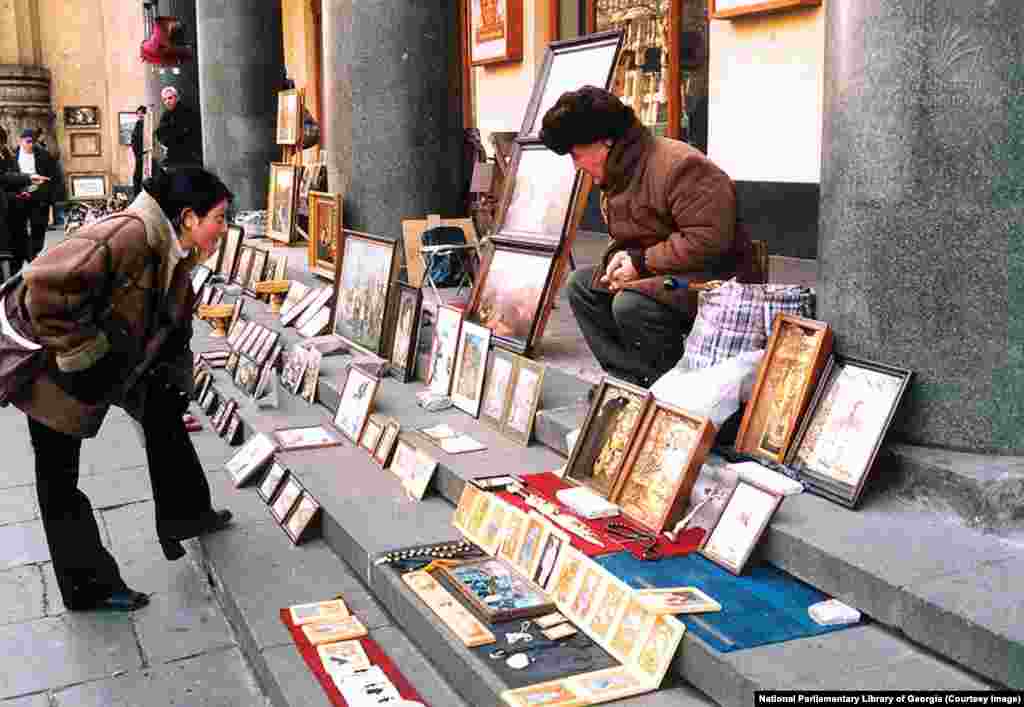 An undated photo of a street vendor selling artwork on Rustaveli Avenue. In independent Georgia, Rustaveli Avenue became a center of shopping and culture, where locals could stroll in the shade of plane trees away from the touristy old town. But with its position in front of the parliament and its potential to effectively shut down Tbilisi&#39;s traffic, &ldquo;all protests, regardless of where they begin,&rdquo; ultimately converge on Rustaveli, Chubinidze says. &nbsp;