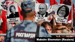 A rally against pension reform in Moscow on September 22. The placards read "Public Enemy" and show President Vladimir Putin (center), Federation Council speaker Valentina Matviyenko (left), and Central Bank Governor Elvira Nabiullina.