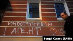 A graffiti message reading "Foreign agent" is spray painted on the wall of the Memorial human rights group's offices in central Moscow.