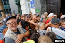 People line up to receive financial aid in Kherson, which is controlled by Russian forces.