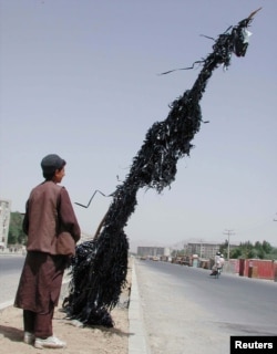 An Afghan boy looks at a pole strung with destroyed video and audio tapes in Kabul in 2001.