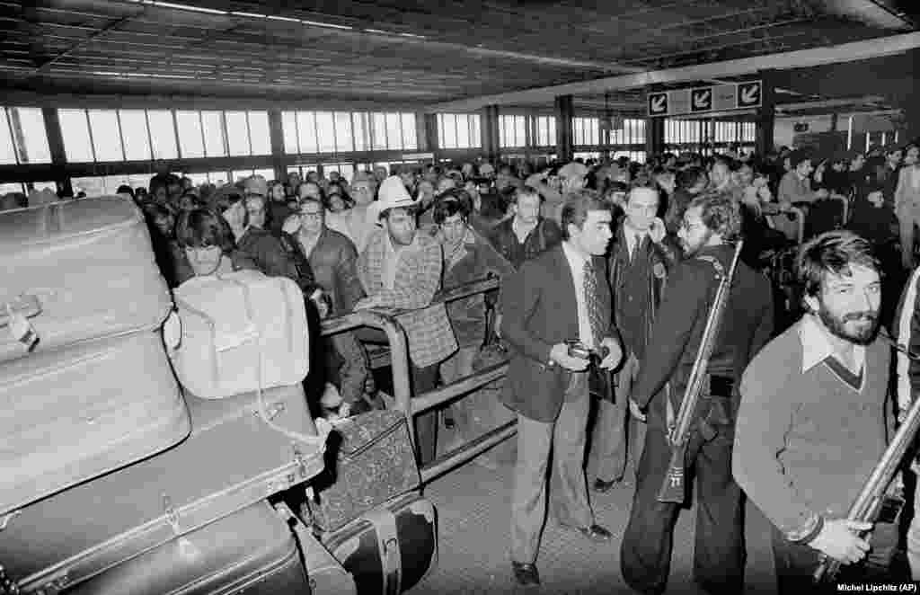 Armed men loyal to Ayatollah Khomeini stand guard at Teheran&#39;s Mehrabad International Airport on February 18, 1979. Hundreds of U.S. citizens attempted to board an evacuation flight to leave Iran.