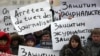 People hold placards as they pay tribute to the 12 people killed by two gunmen at the French weekly newspaper Charlie Hebdo's editorial office, outside French Embassy in Moscow on January 9.