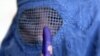 At a Kabul polling station, an election worker cleans and applies ink on a voter's finger 