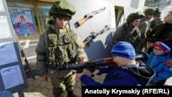 Children play with military equipment at a celebration of the Russian Defender of the Fatherland Day in Simferopol, Crimea, in February 2020.