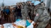 UN personnel carry away a victim of the Markale market attack in Sarajevo on February 6, 1994. 