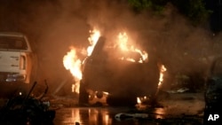 A vehicle is engulfed by flames at the site of a deadly explosion outside Karachi airport on October 6. 