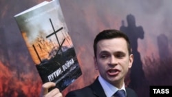 Opposition activist Ilya Yashin speaks to the media during a presentation of the Nemtsov report in Moscow on May 12.