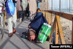 A woman and child beg on the street in Ghazni city.