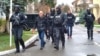 Police escort Romanian mercenary Horatiu Potra (center) in Bucharest on December 8.