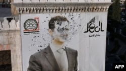 A bullet-riddled portrait of Bashar al-Assad in the city of Hama