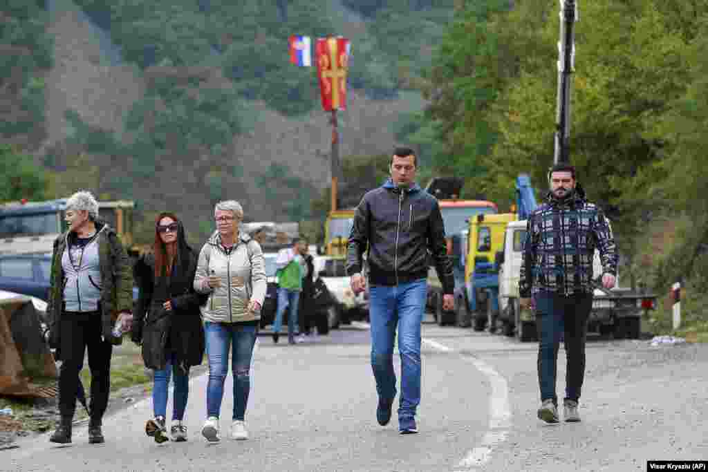 Ethnic Serbs walk through barricades near the Jarinje crossing on September 28. On September 27, Kosovar Prime Minister Albin Kurti repeated an offer for both countries to lift the rule of temporary license plates. He also said he was open to talks in Brussels, but Belgrade was refusing to hold them.