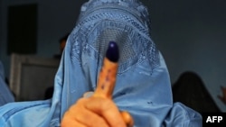 Afghanistan -- An Afghan woman shows her inked finger after voting at a polling station in the northwestern city of Herat, April 5, 2014