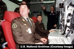 Two senior officers from Russia's Strategic Rocket Forces sit in the chairs of a U.S. nuclear missile simulator used for training.