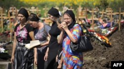 Relatives and friends of a flood victim mourn at his grave in a cemetery in the town of Krymsk in the southern Krasnodar region. 