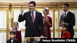 Turkmen President Gurbanguly Berdymukhammedov (center) casts his ballot as his son Serdar (right) stands with other family members at a polling station in Ashgabat in February 2017.