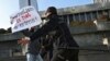 Police officers restrain a protester during a rally of journalists against a new media bill, in front of the parliament building in Baku on December 28. 