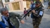 A Taliban special forces officer pushes a journalist covering a demonstration by women protesters outside a school in Kabul. (file photo)