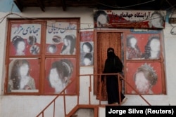 A woman wearing a niqab enters a beauty salon in Kabul.