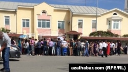 People wait outside the Russian Embassy in Ashgabat, waiting to apply for travel or work documents, in May 2019.