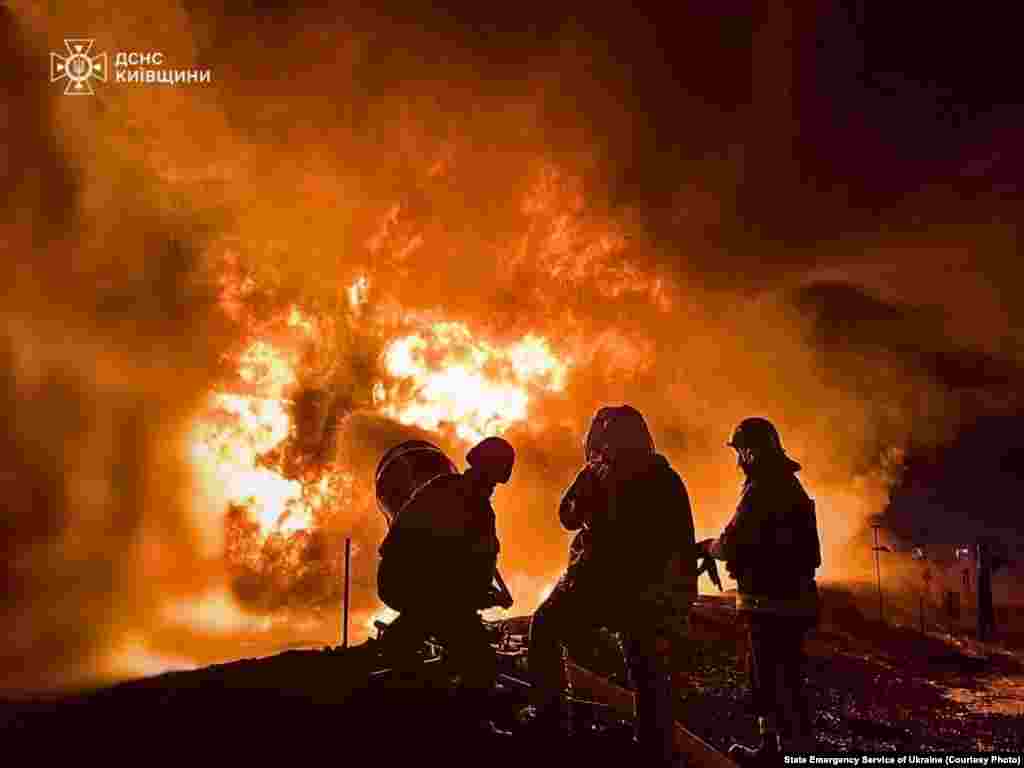 Ukrainian firefighters tackle a blaze at an industrial facility following a Russian drone attack on the Kyiv region. 