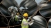 Workers pull a rope next to pipes during the arrival ceremony of the first Trans-Adriatic Pipeline pipes in Spitalle, near Durres, Albania, in April 2016.