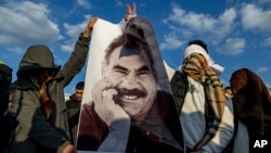 Supporters in Diyarbakir, Turkey, hold a banner of Kurdish leader Abdullah Ocalan as they celebrate his peace call on February 28.