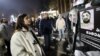 A woman in Tbilisi on December 9 looks at a poster showing people reportedly beaten by Georgian police.